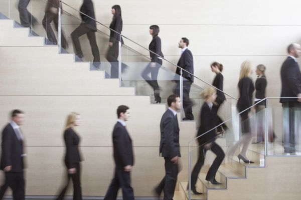 a single-file line of business people walking up a staircase