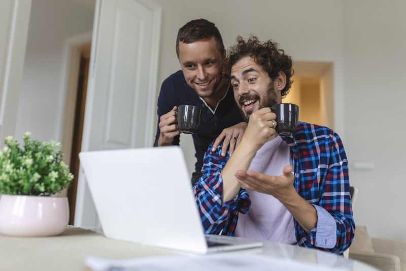 Couple discuss over laptop with cups of tea
