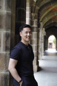 A man wearing a polo shirt standing on an alley