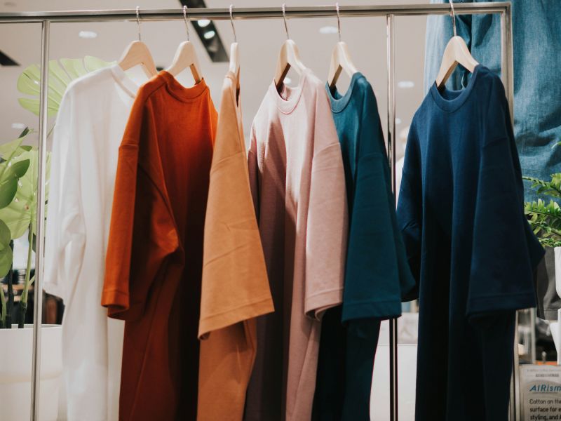 A few clothing are displayed on a clothing rack