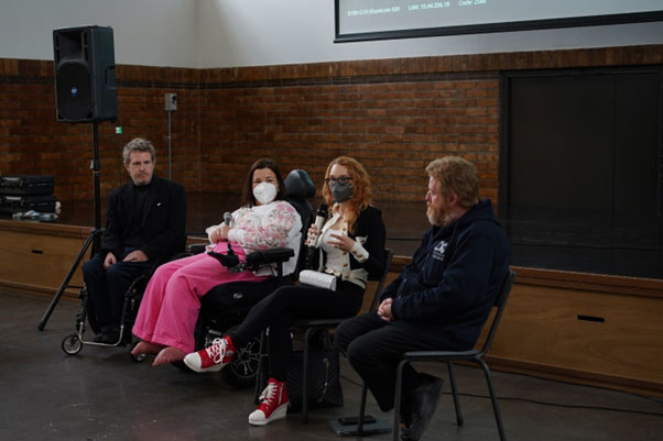 four people of all-abilities speaking to a room of people