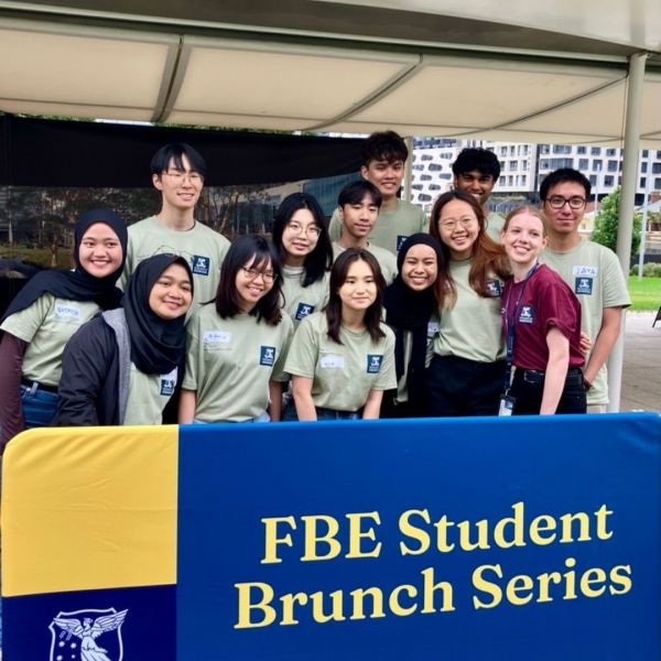 FBE Student Ambassadors taking photo near the FBE Student Brunch banner