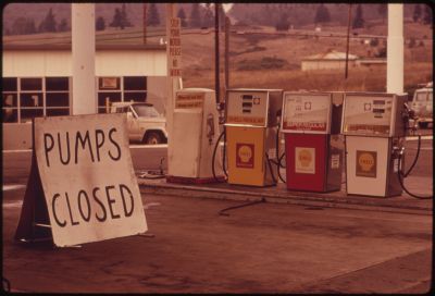 A image taken in the 1970s of three petrol pumps, behind a sign that reads 