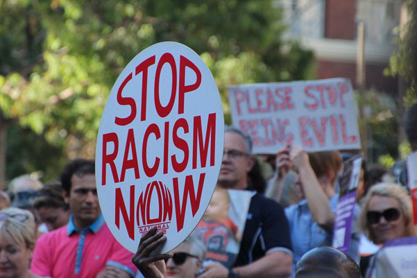 stop racism now sign at a protest