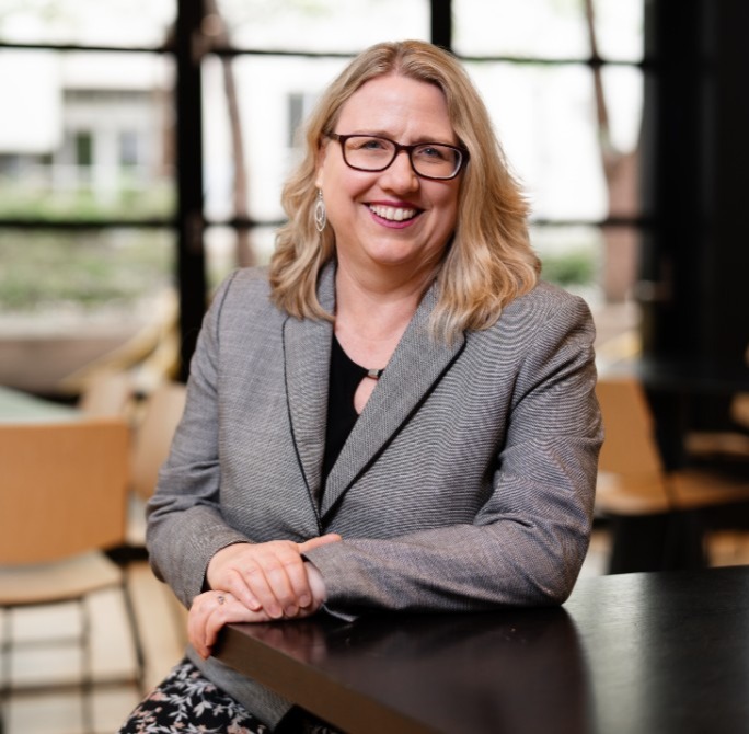 Image for A woman wearing a grey suit and glaseses
