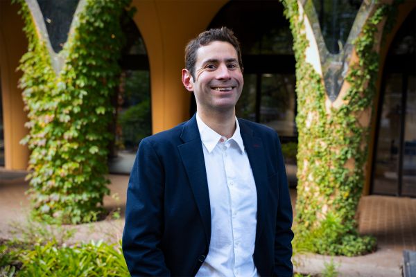 Man standing with hands in pocket smiling at camera