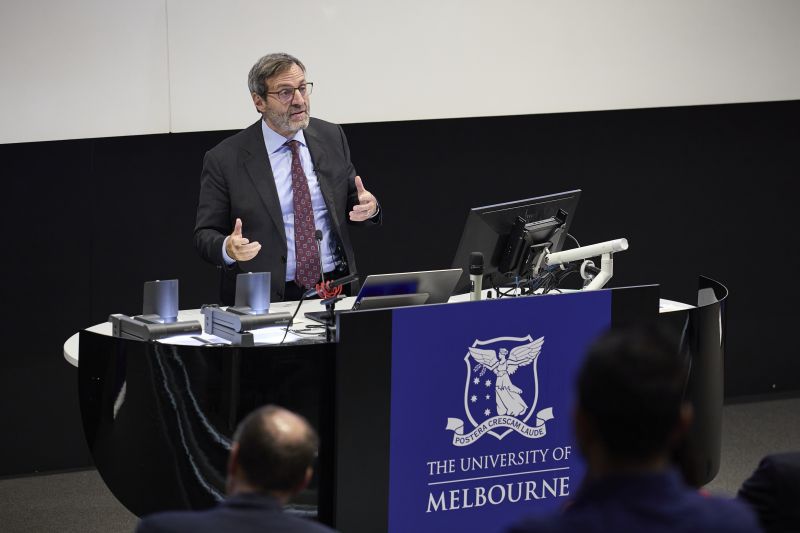 man standing behind lectern delivering lecture