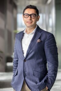 A man wearing white business shirt and blue stripe suit